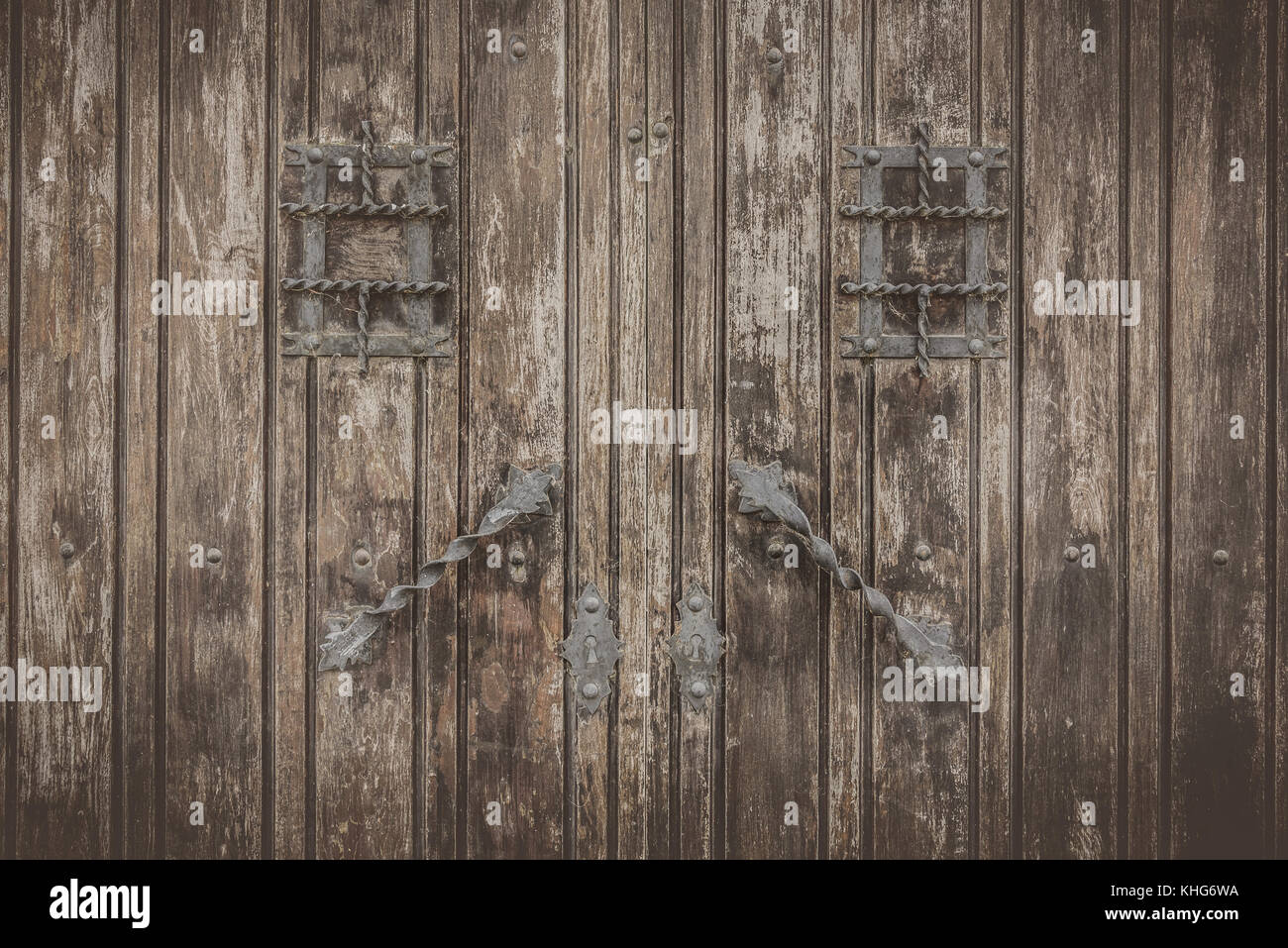 Rustic wooden textured door with wrought Iron fittings Stock Photo