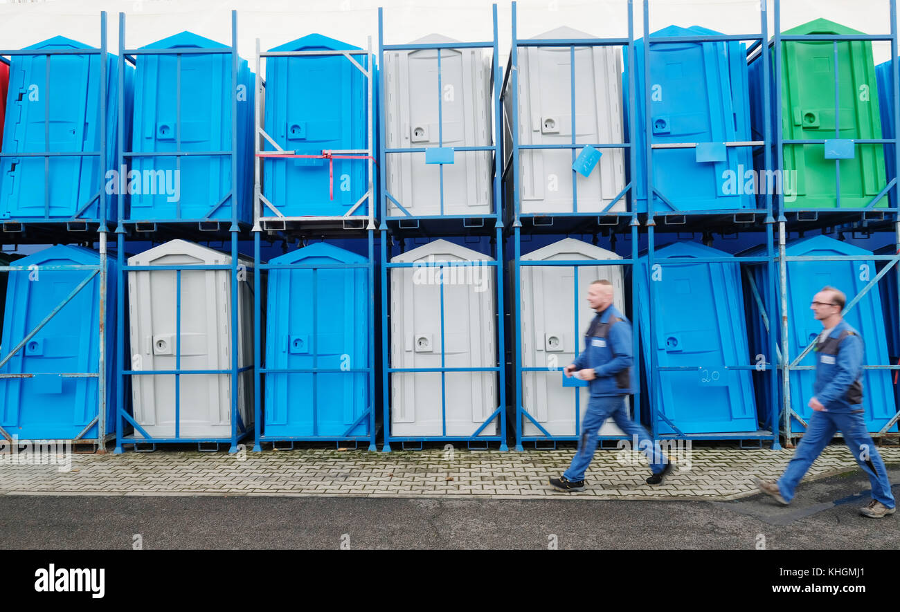 Coswig, Germany. 16th Nov, 2017. An employee of the Global Fliegenschmidt GmbH can be seen walking by stacked rental toilets in Coswig, Germany, 16 November 2017. The company specialized in manufacturing mobile toilets and sanitary wagons. Credit: Sebastian Willnow/dpa-Zentralbild/dpa/Alamy Live News Stock Photo