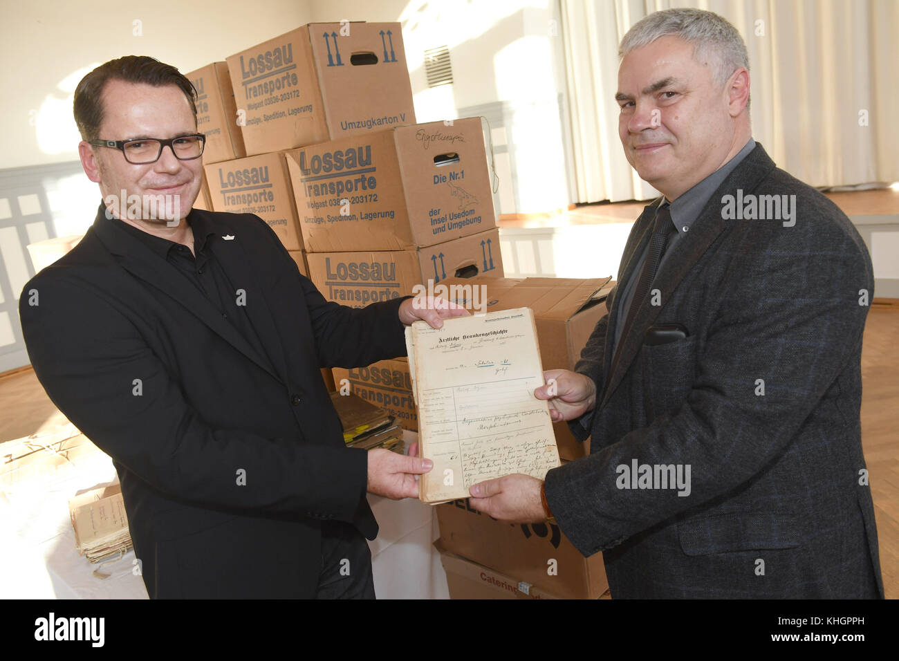 Stralsund, Germany. 17th Nov, 2017. Dr. Jan Armbruster (L), leading senior physician of the Stralsund forensic psychiatry, hands the Fallada file from 1921 to head of the national archive Martin Schoebel in Stralsund, Germany, 17 November 2017. The renown author Rudolf Ditzen, whose pseudonym is Hans Fallada, is among about 1000 files of patients between 1912 and 1939 that are being handed over to the national archive in Mecklenburg-Western Pomerania. Credit: Stefan Sauer/dpa/Alamy Live News Stock Photo