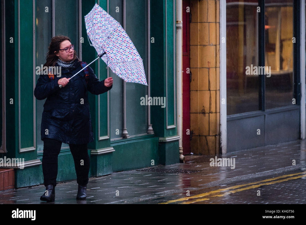 Aberystwyth  Wales UK, Saturday 18 Novemberr 2017  UK Weather A woman struggling with her umbrella on a grey, overcast, wet and rainy  morning  in Aberystwyth Wales UK      Photo © Keith Morris / Alamy Live News Stock Photo