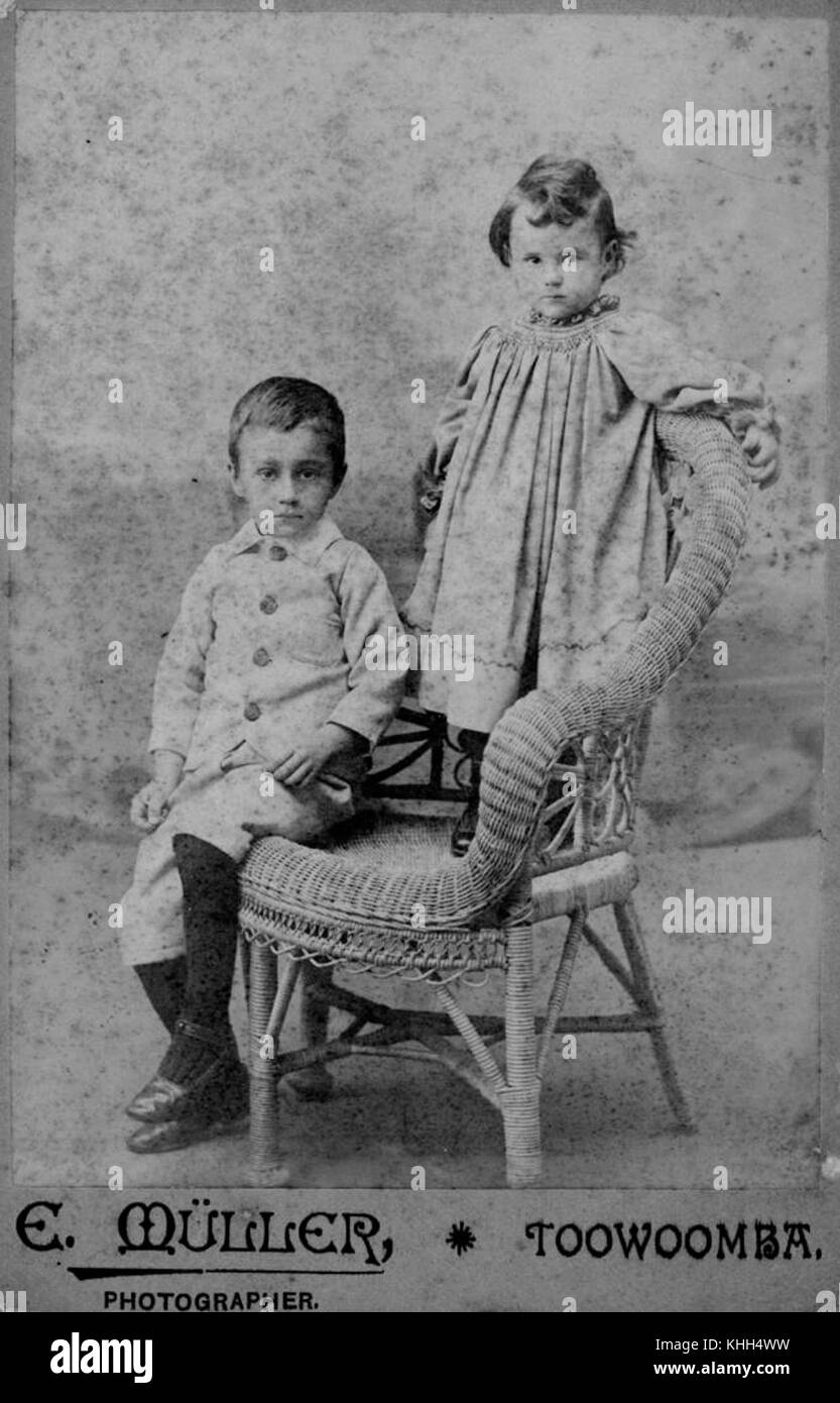 1 197215 Portrait of two children posing on a cane chair, Toowoomba