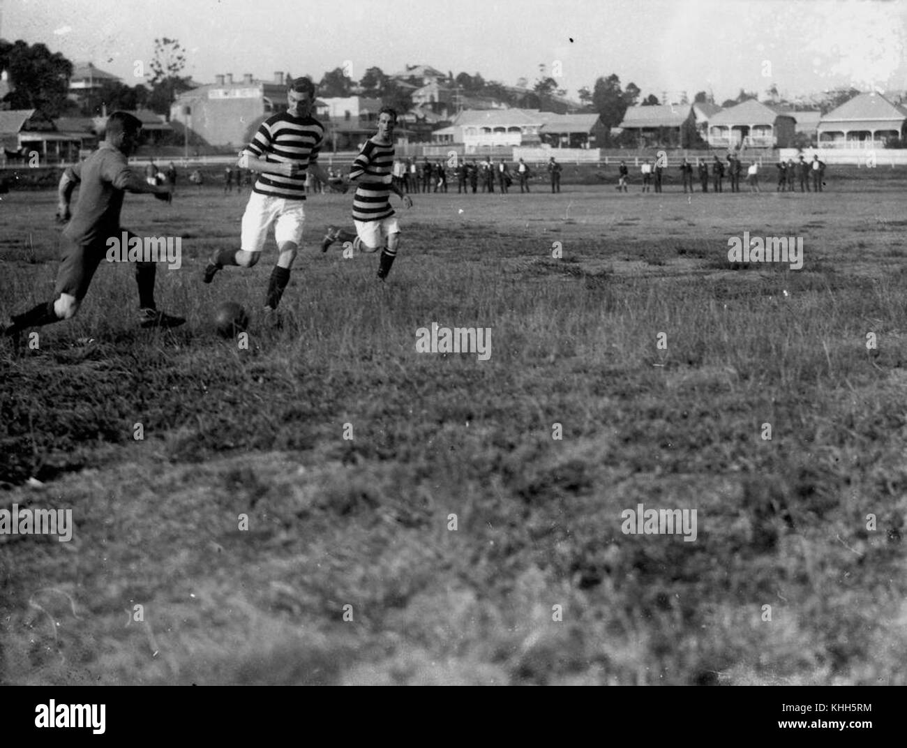 This early 20th-century photograph captures soccer players in Brisbane, Australia, at a match circa 1914, documenting early sports history in the region. Stock Photo