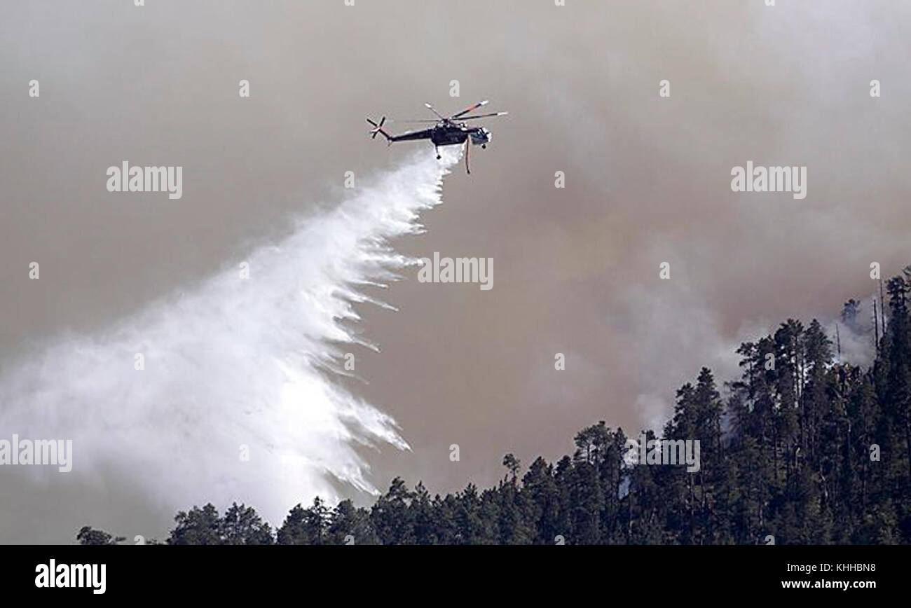 A helicopter makes water drop on the Crow Peak Fire. The Crow Peak Fire located in the Black Hills National Forest near Spearfish, SD began on Jun. 24, 2016 started by lightning.  The Crow Peak Fire has consumed 1,350 acres. U.S. Forest Service photo. Stock Photo