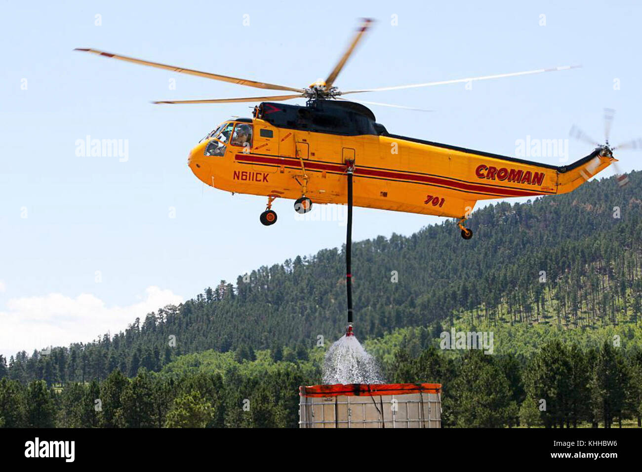 A helicopter fills its water bucket at mobile water station to use against the Crow Peak Fire. The Crow Peak Fire located in the Black Hills National Forest near Spearfish, SD began on Jun. 24, 2016 started by lightning.  The Crow Peak Fire has consumed 1,350 acres. U.S. Forest Service photo. Stock Photo
