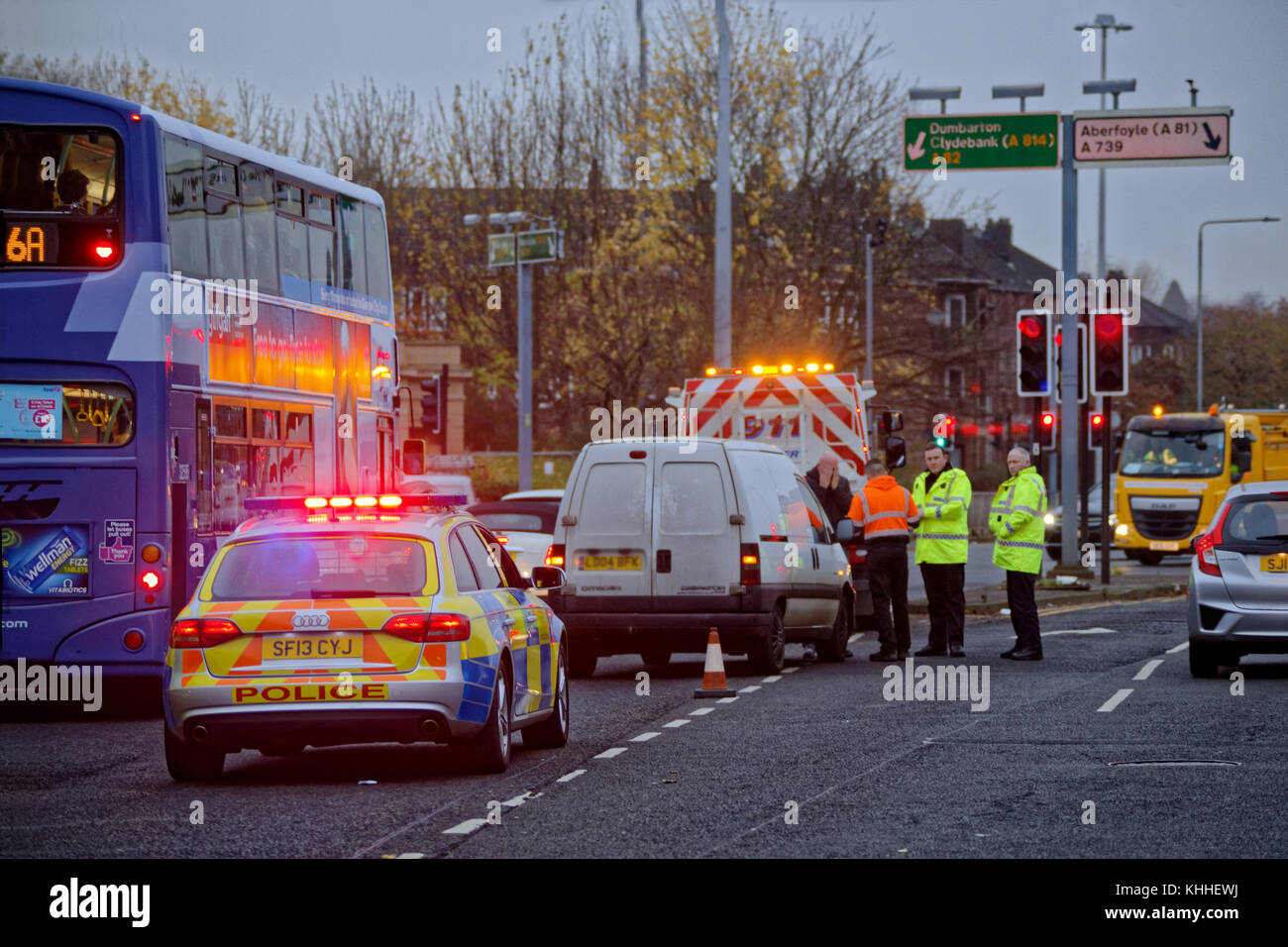 white van man pulled over by police in the middle of the road flashing lights traffic incident Stock Photo