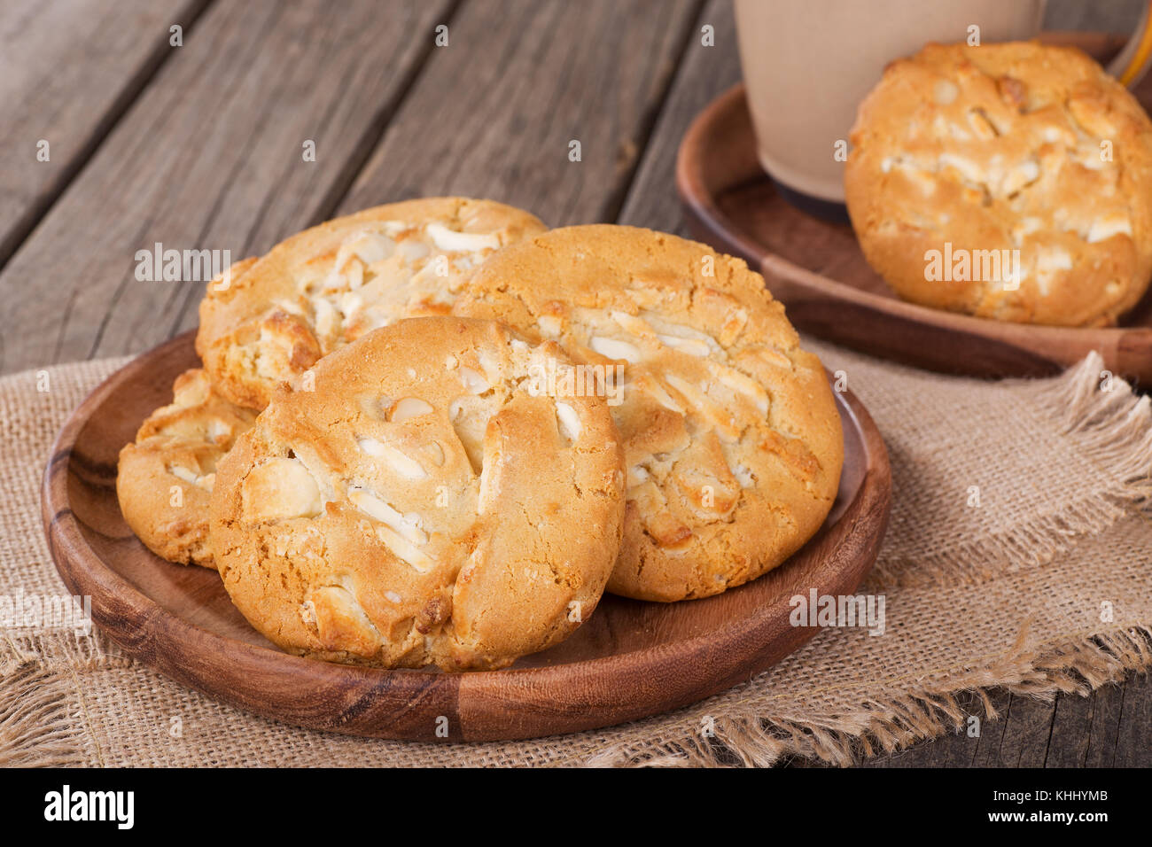 Closeup of white chocolate macadamia nut cookies on a wooden plate Stock Photo