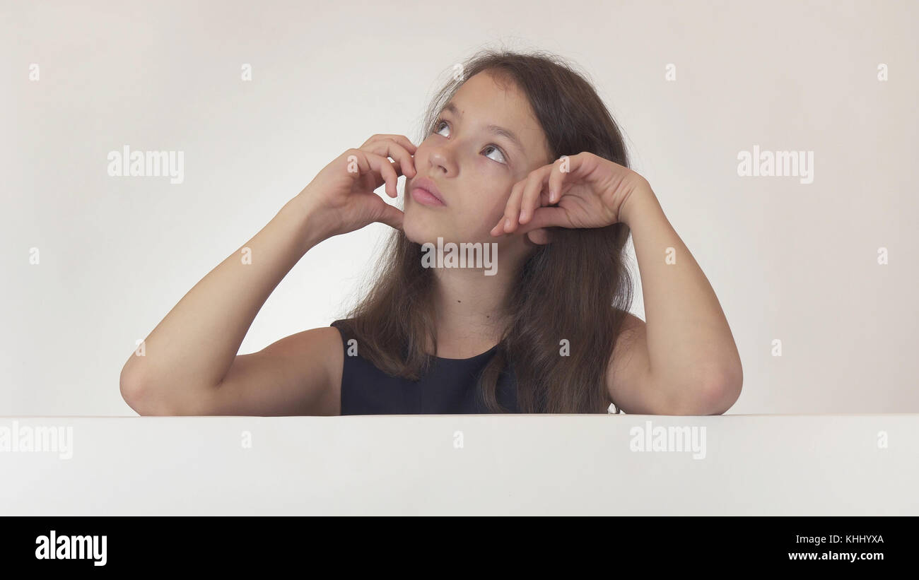 Beautiful Girl Teenager Pondered Over The Poster With Information On White Background Beautiful Girl Teenager Pondered Over The Poster With Information On White Background