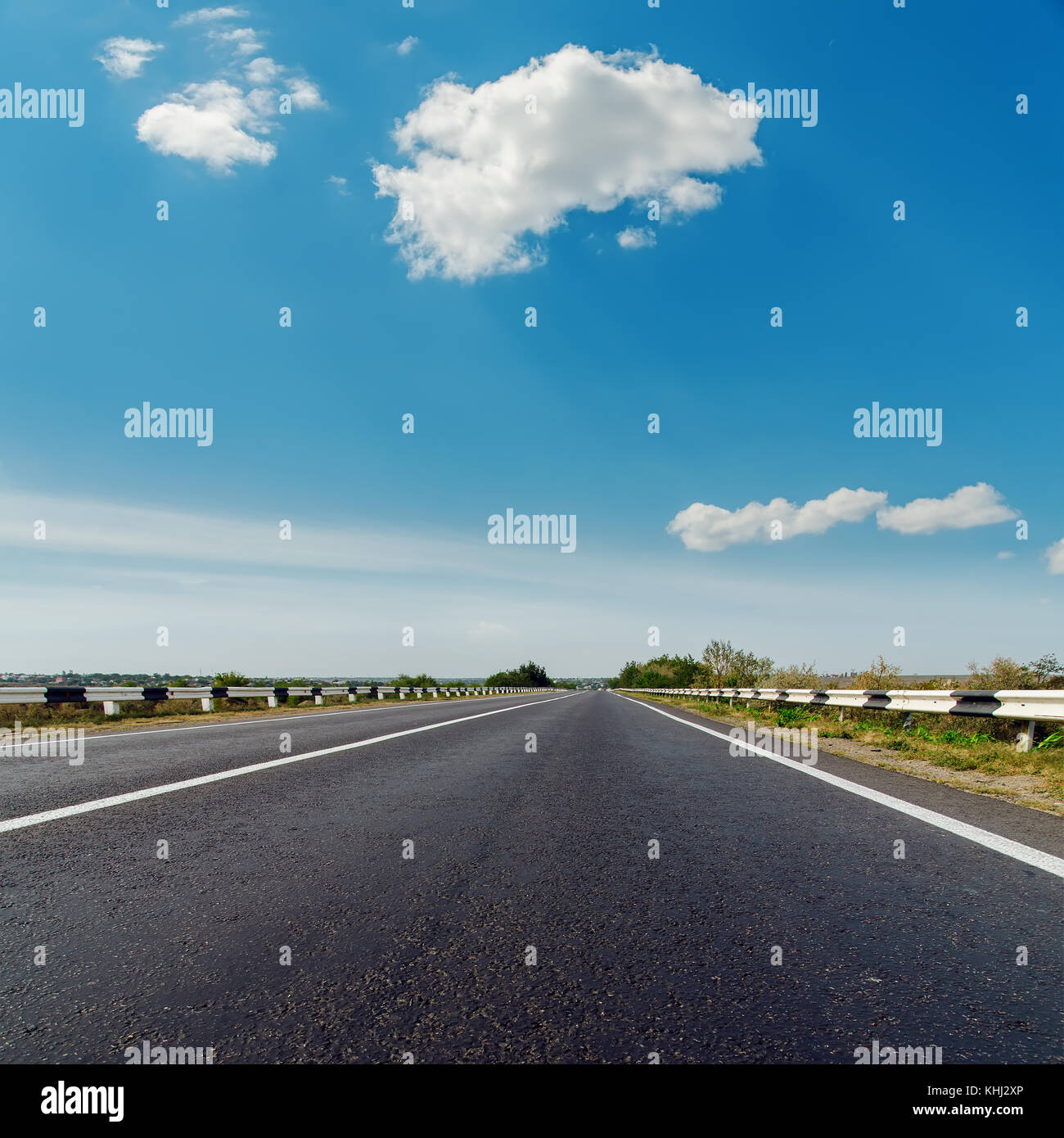 asphalt road to horizon under blue cloudy sky Stock Photo - Alamy