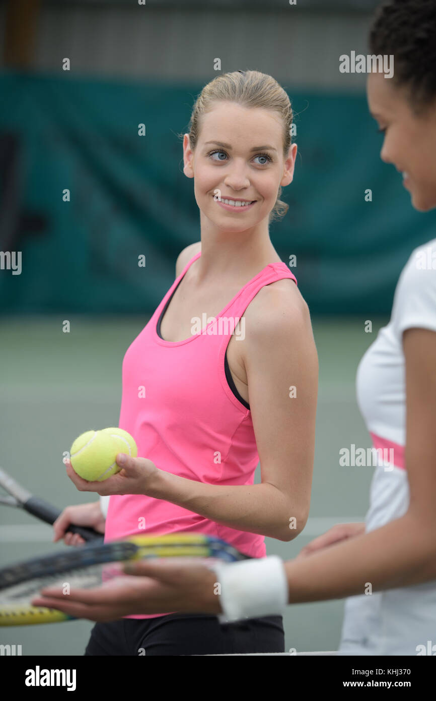 female tennis player standing and smiling on court Stock Photo Alamy
