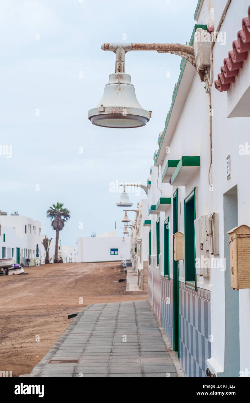 view of a typical street with a street light in the foreground, La Graciosa, Canary Islands, Spain Stock Photo