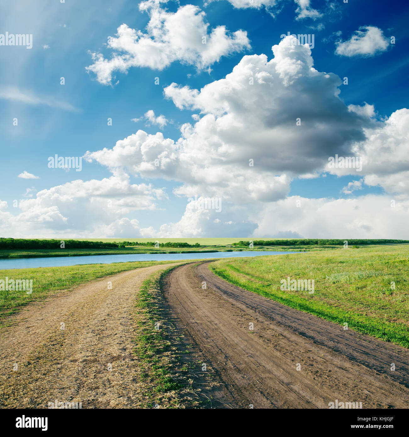 rural road in green grass and cloudy sky Stock Photo - Alamy