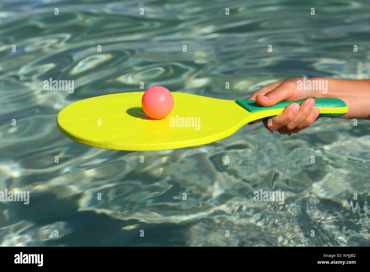 A ball and a racket in the water, to play paddle or beach ball fun game