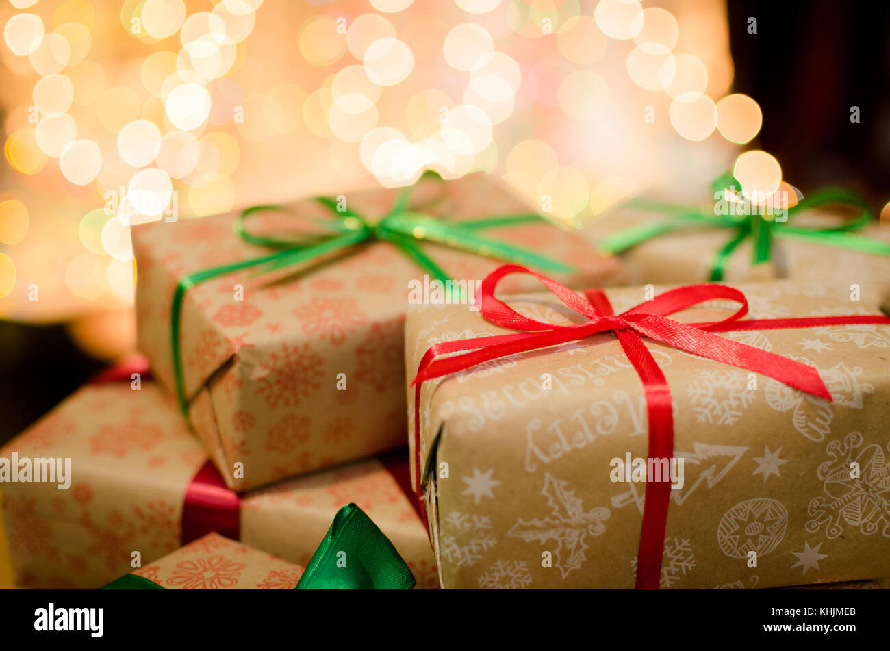 christmas gift boxes wrapped in themed craft paper and satin red and ...
