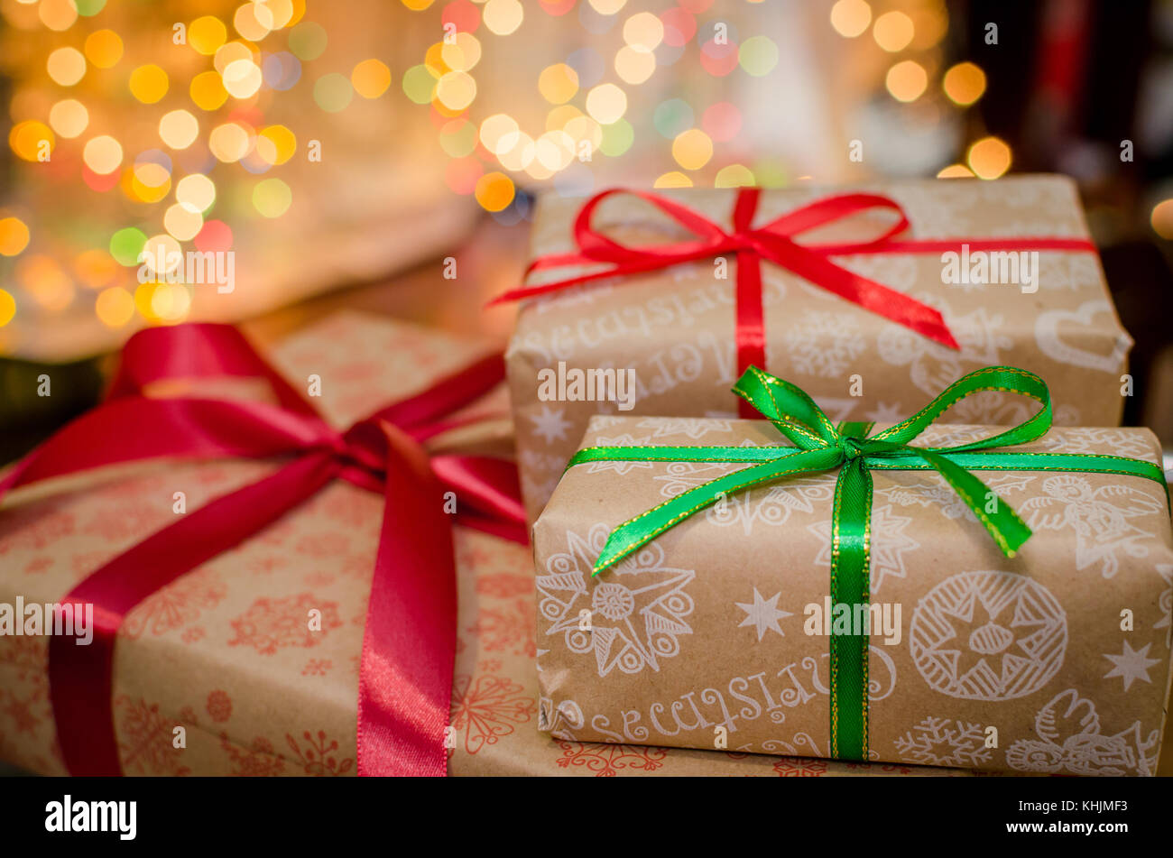 christmas gift boxes wrapped in themed craft paper and satin red and ...