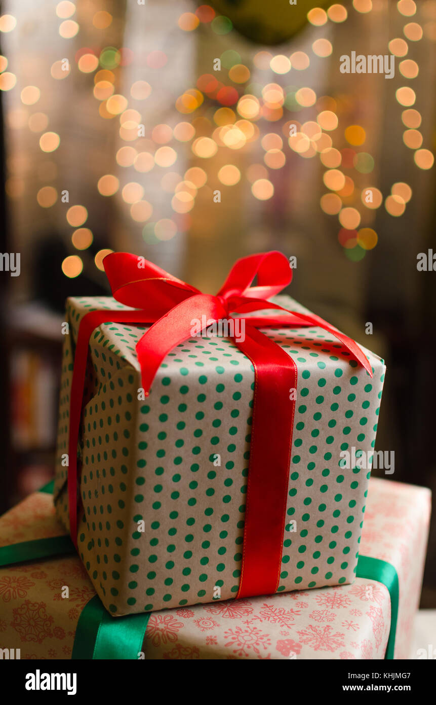 christmas gift boxes wrapped in themed craft paper and satin red bow ...