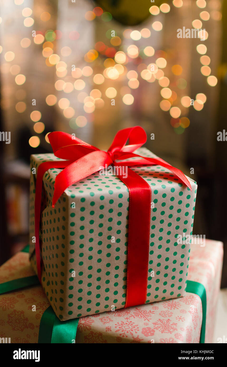 christmas gift boxes wrapped in themed craft paper and satin red bow ...