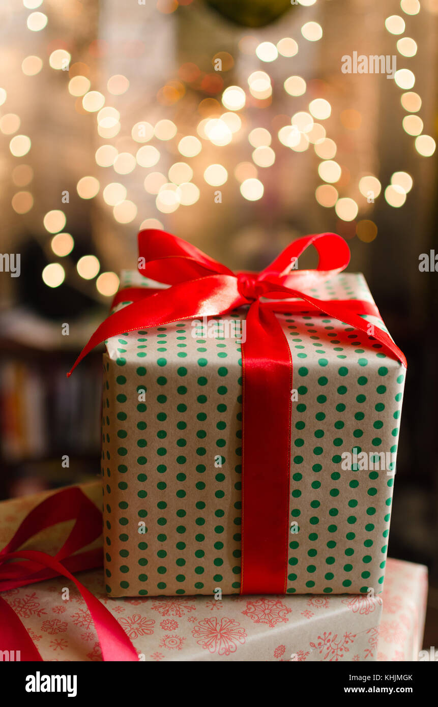 christmas gift boxes wrapped in themed craft paper and satin red bow ...