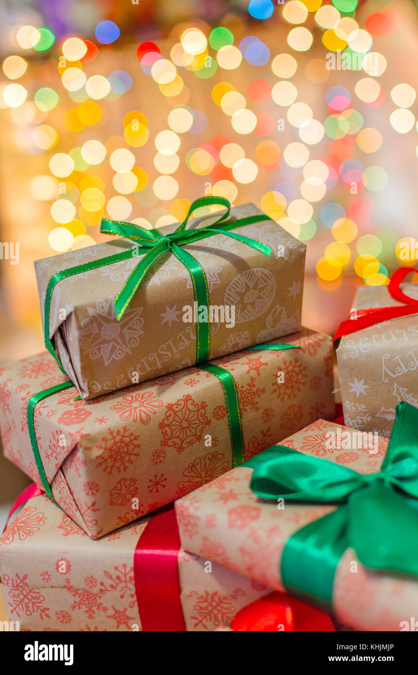 christmas gift boxes wrapped in themed craft paper and satin red and ...