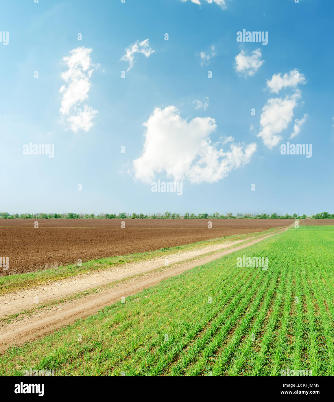 green field with road and clouds in blue sky Stock Photo - Alamy