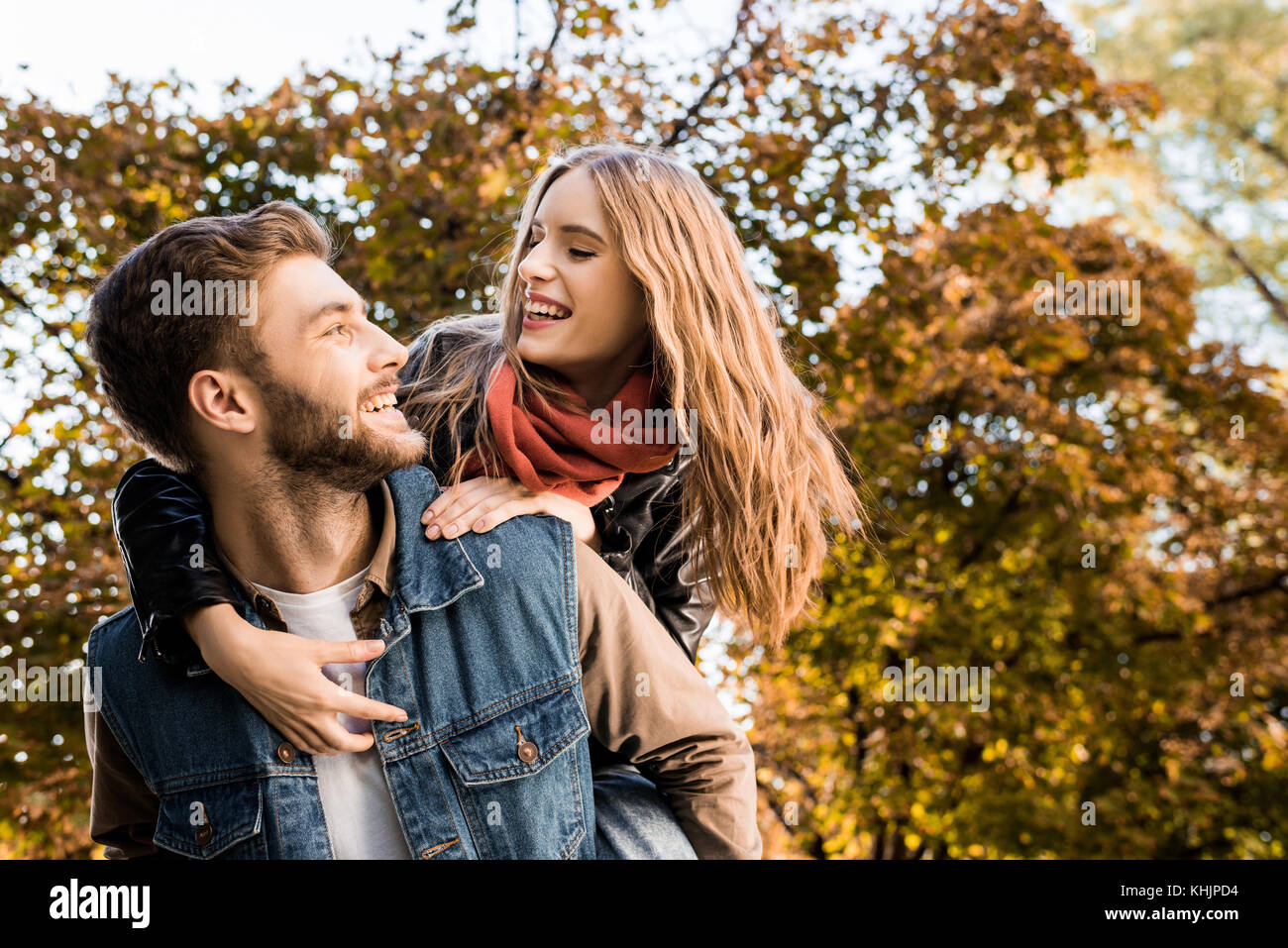 couple piggybacking in autumn park Stock Photo