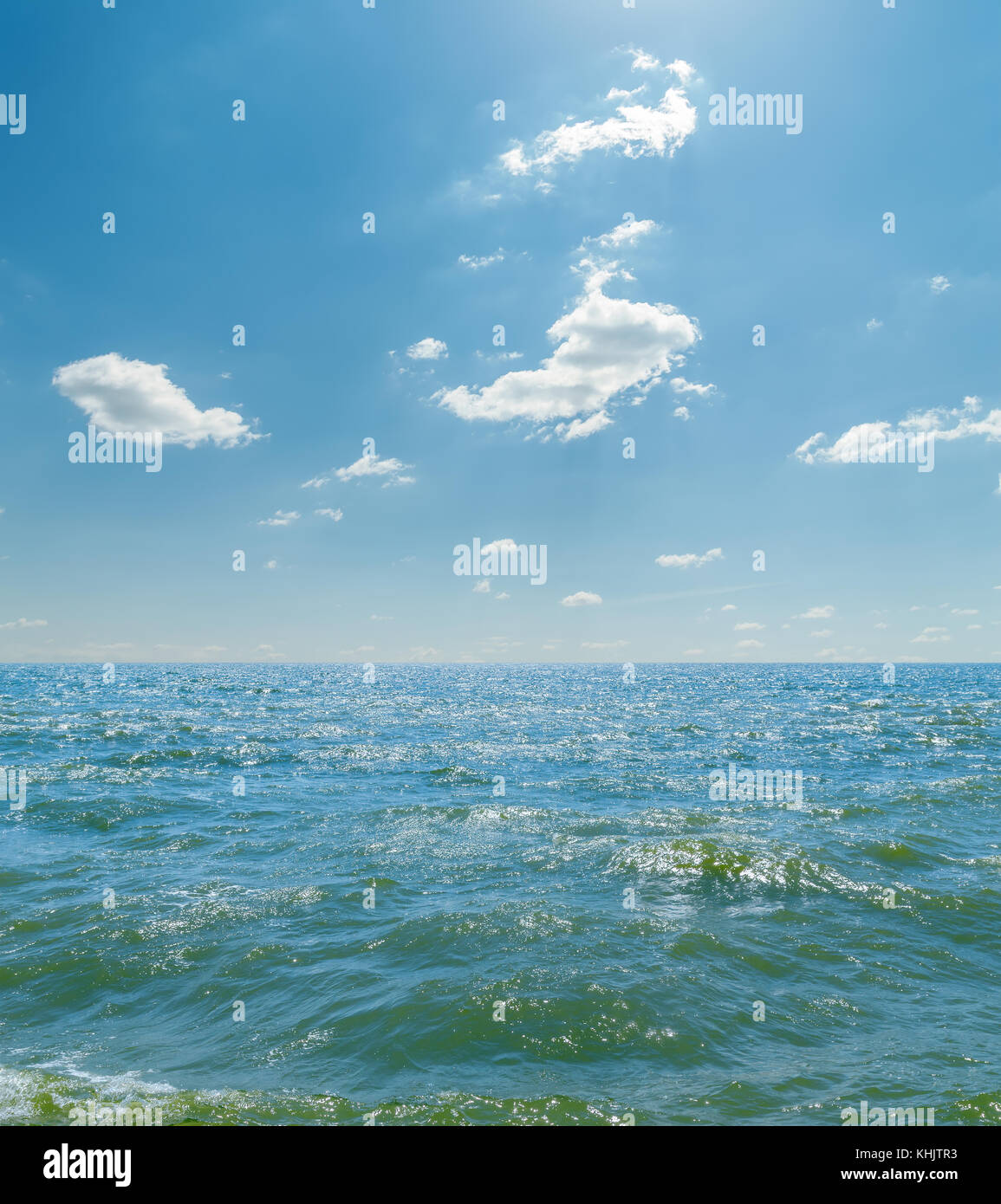 sea with waves and clouds in blue sky Stock Photo - Alamy