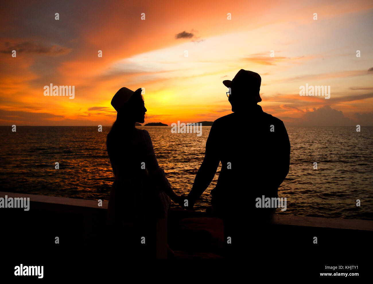 Silhouette of happy young couple in beautiful sunset Stock Photo - Alamy