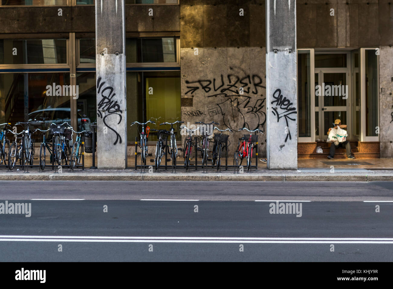 Homeless Bologna. A homeless man sits on a building steps among