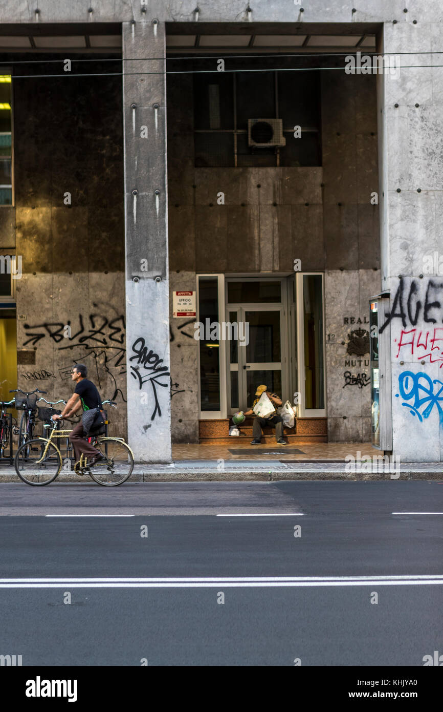 Homeless Bologna. A homeless man sits on a building steps among