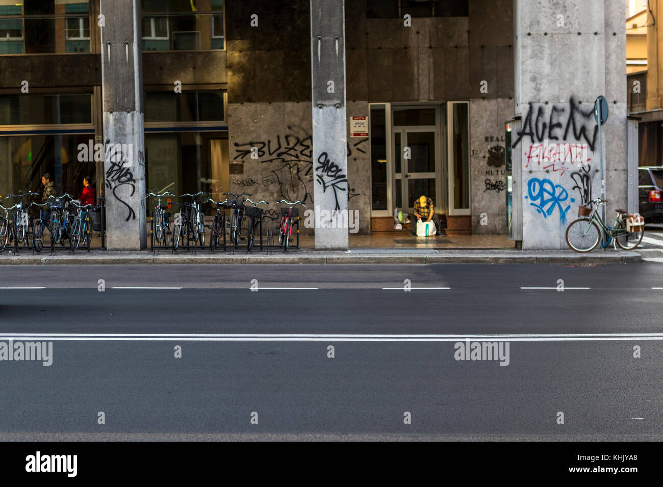 Homeless Bologna. A homeless man sits on a building steps among