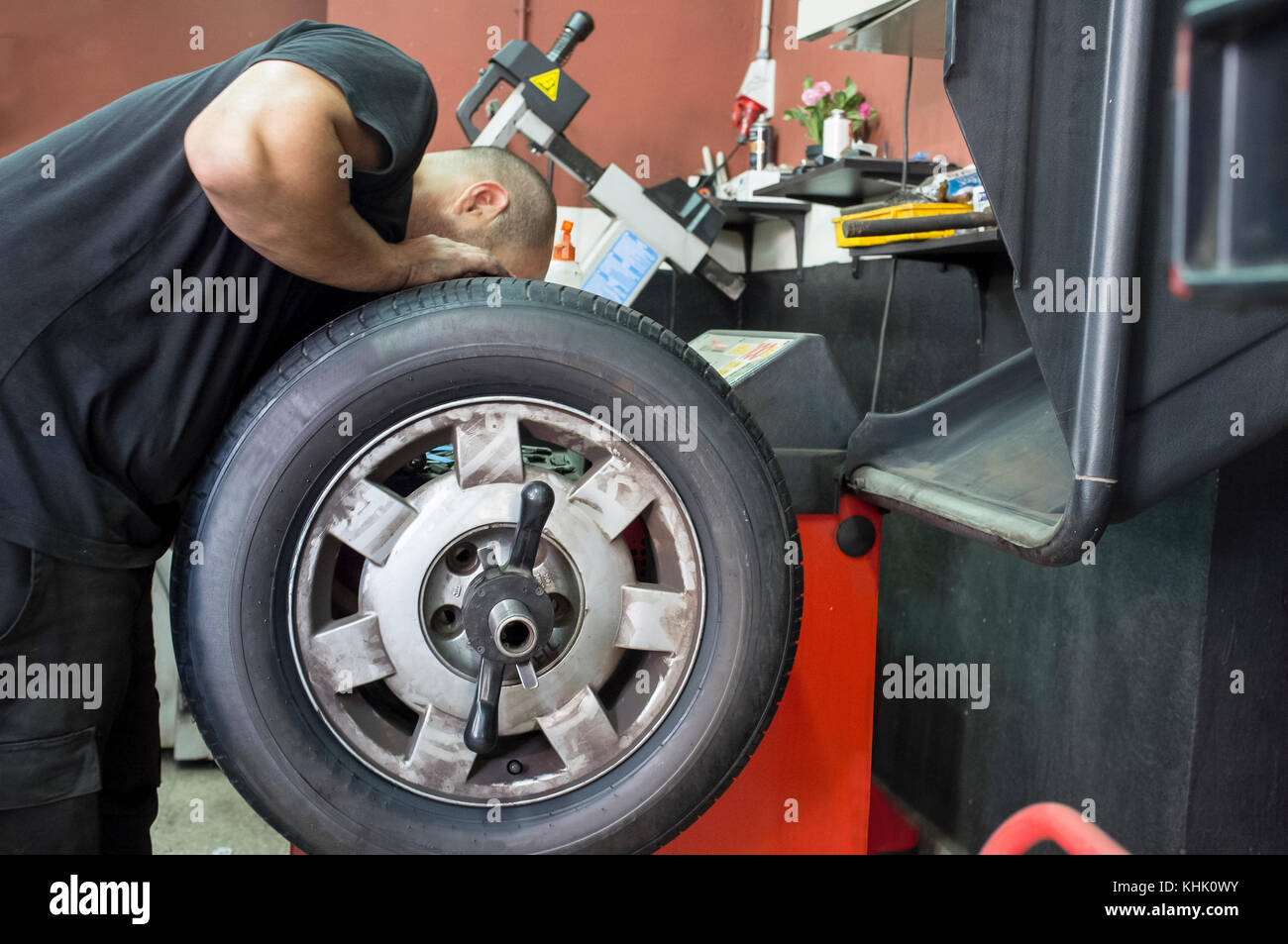 Technician work with mechanic balancing wheel. Installing wheel process Stock Photo