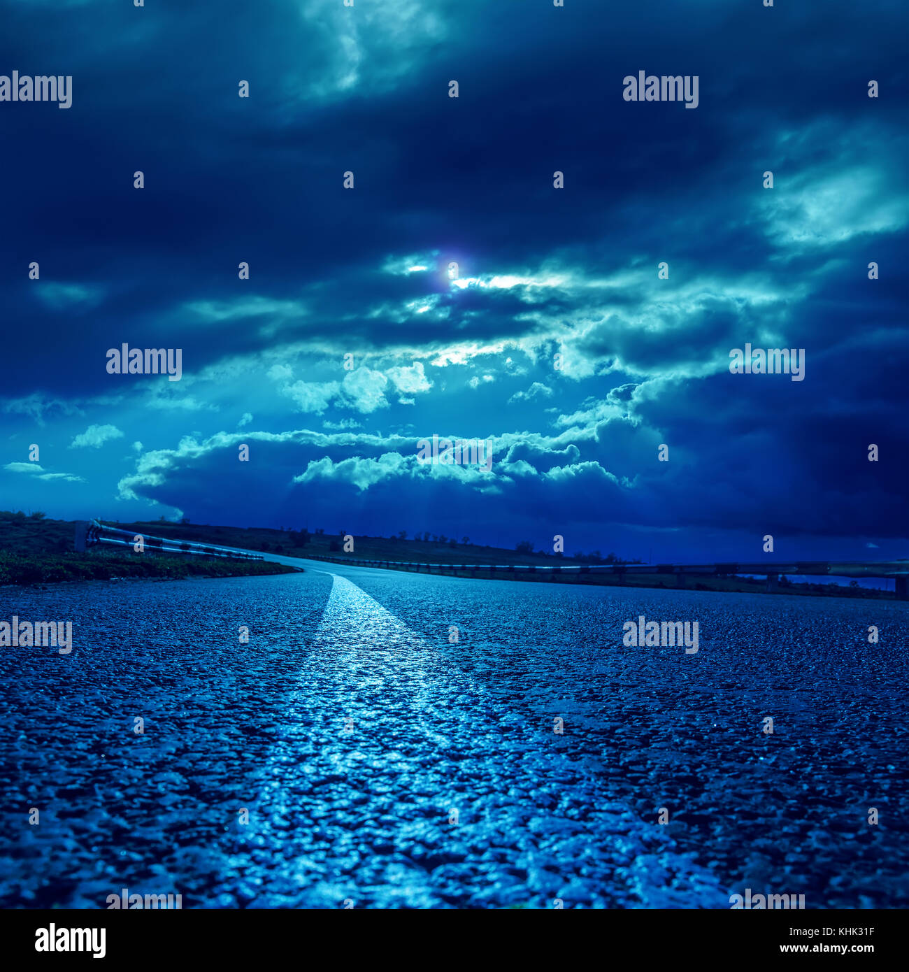 low dramatic clouds over asphalt road in dark blue moonlight Stock ...