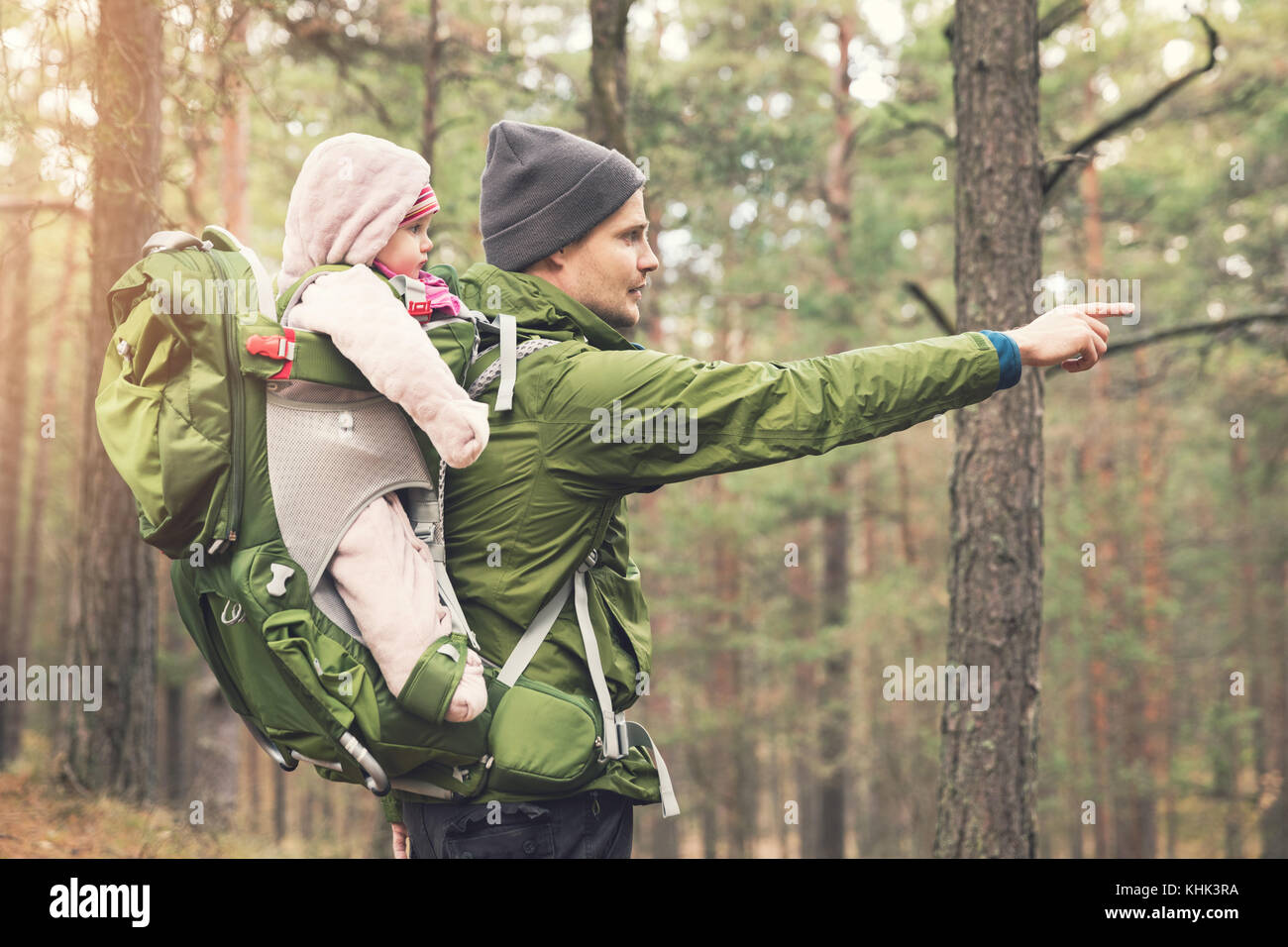 father with baby in child carrier on a hike in the woods Stock Photo