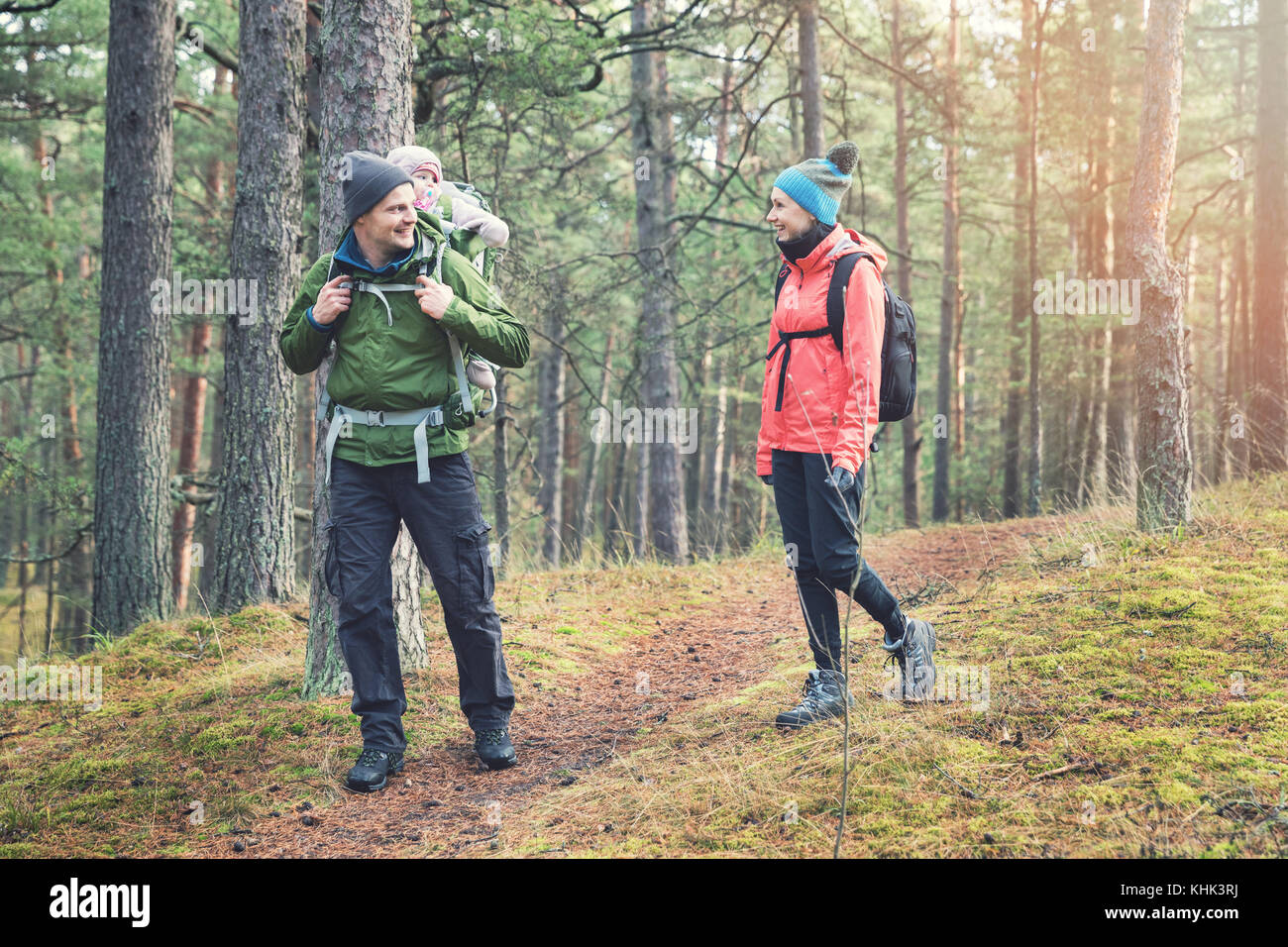 family hiking in the forest with baby in child carrier Stock Photo