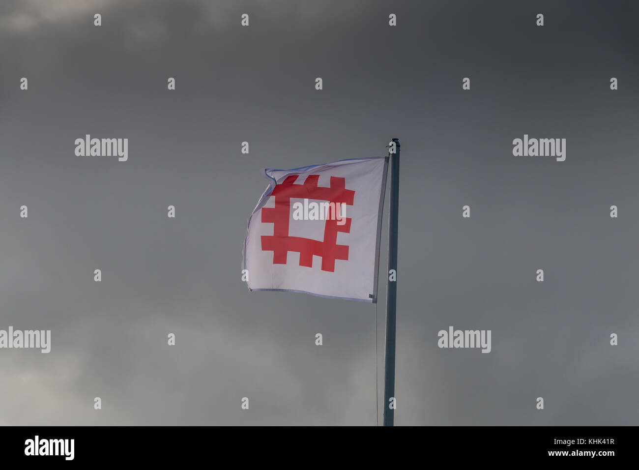 English Heritage flag flying from a flagpole against a grey sky background wit copy space Stock Photo