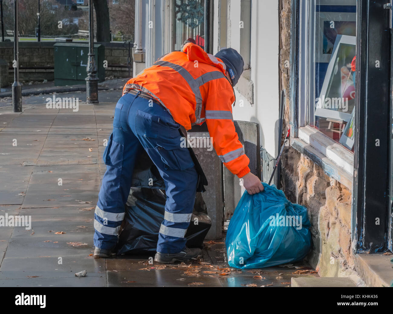 A Durham County Council worker in orange High Visibility coat emptying a  street rubbish bin Stock Photo - Alamy