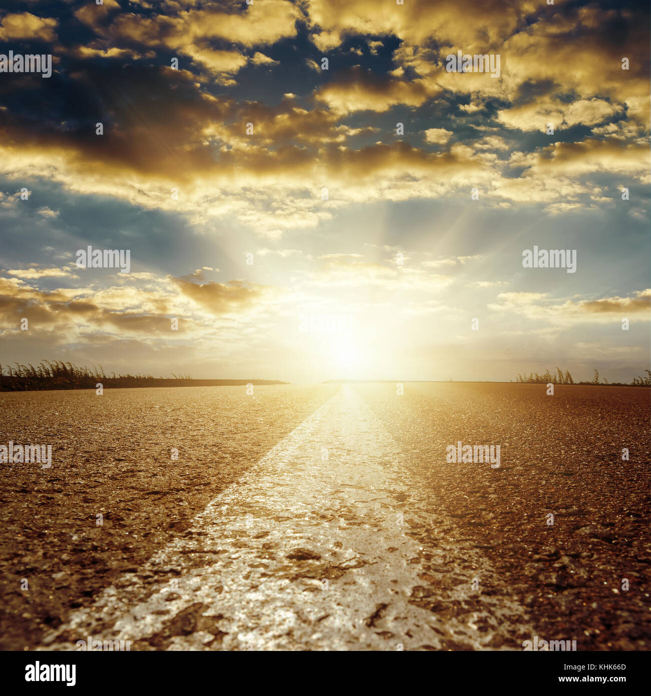 sunset in low clouds over asphalt road with central white line Stock ...