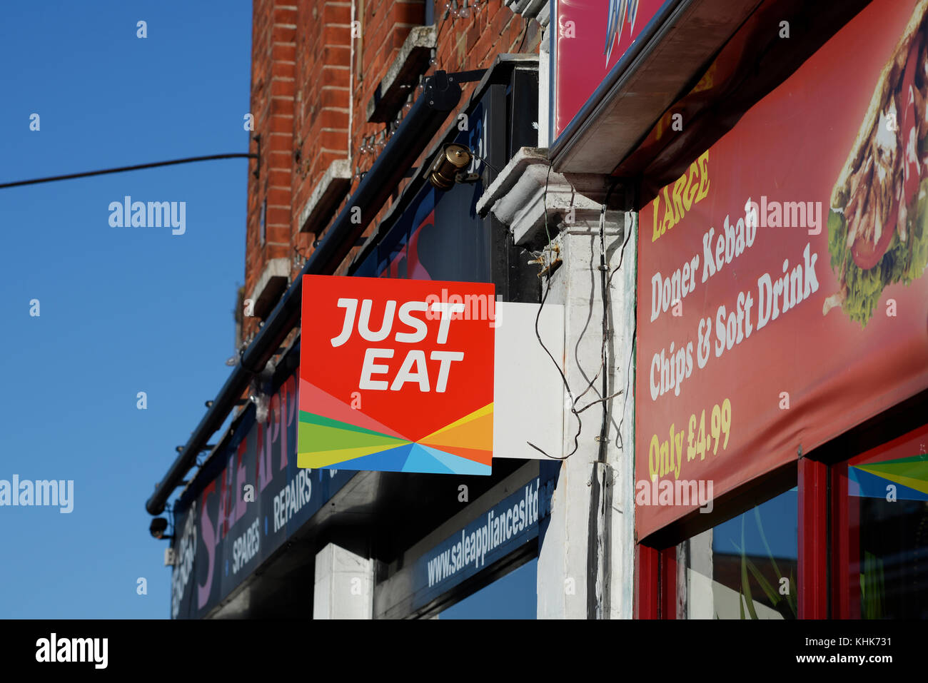 Just Eat sign food ordering application outside fast food take away restaurant. Kebab Stock Photo