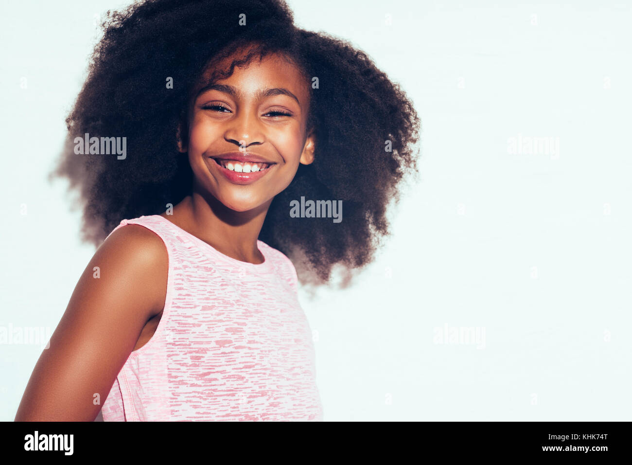 Happy African Teenage Girl With Curly Hair Smiling While Standing