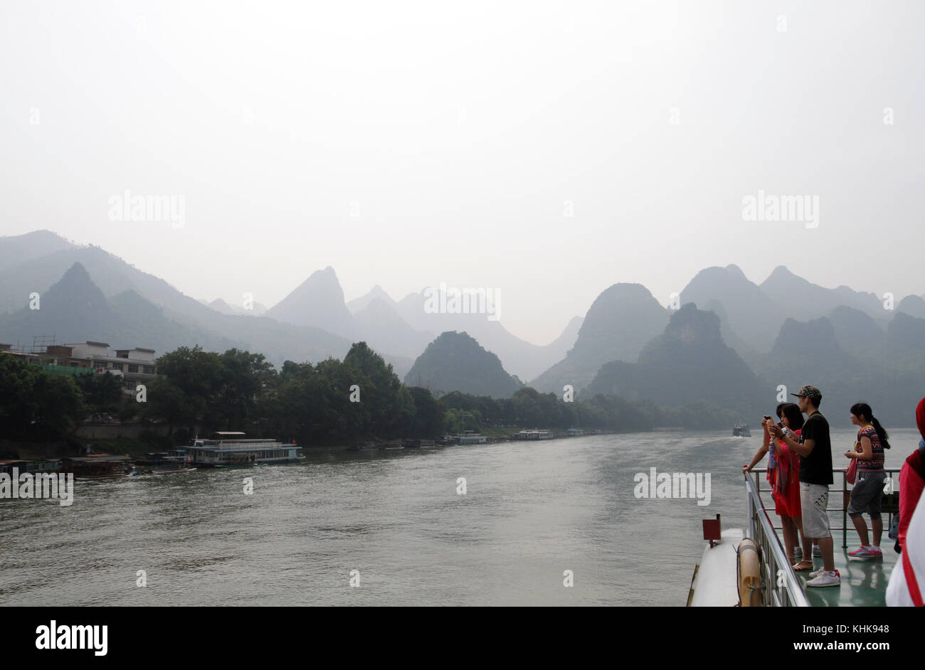 Tourists on a boat taking photos in Guilin, China. Stock Photo