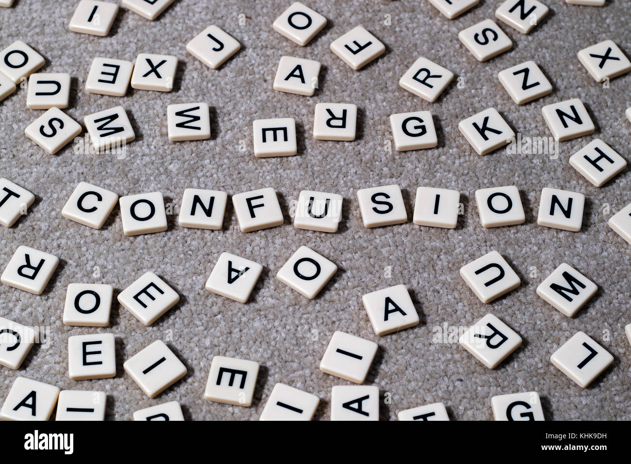 Confusion spelled out on scrabble style lettered tiles amongst a jumble of other letters. Stock Photo