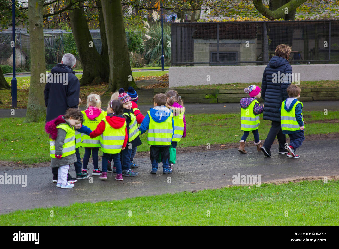 A children's playgroup in high visibility vests on a walk with adults through Ward Park in Bangor County Down Stock Photo
