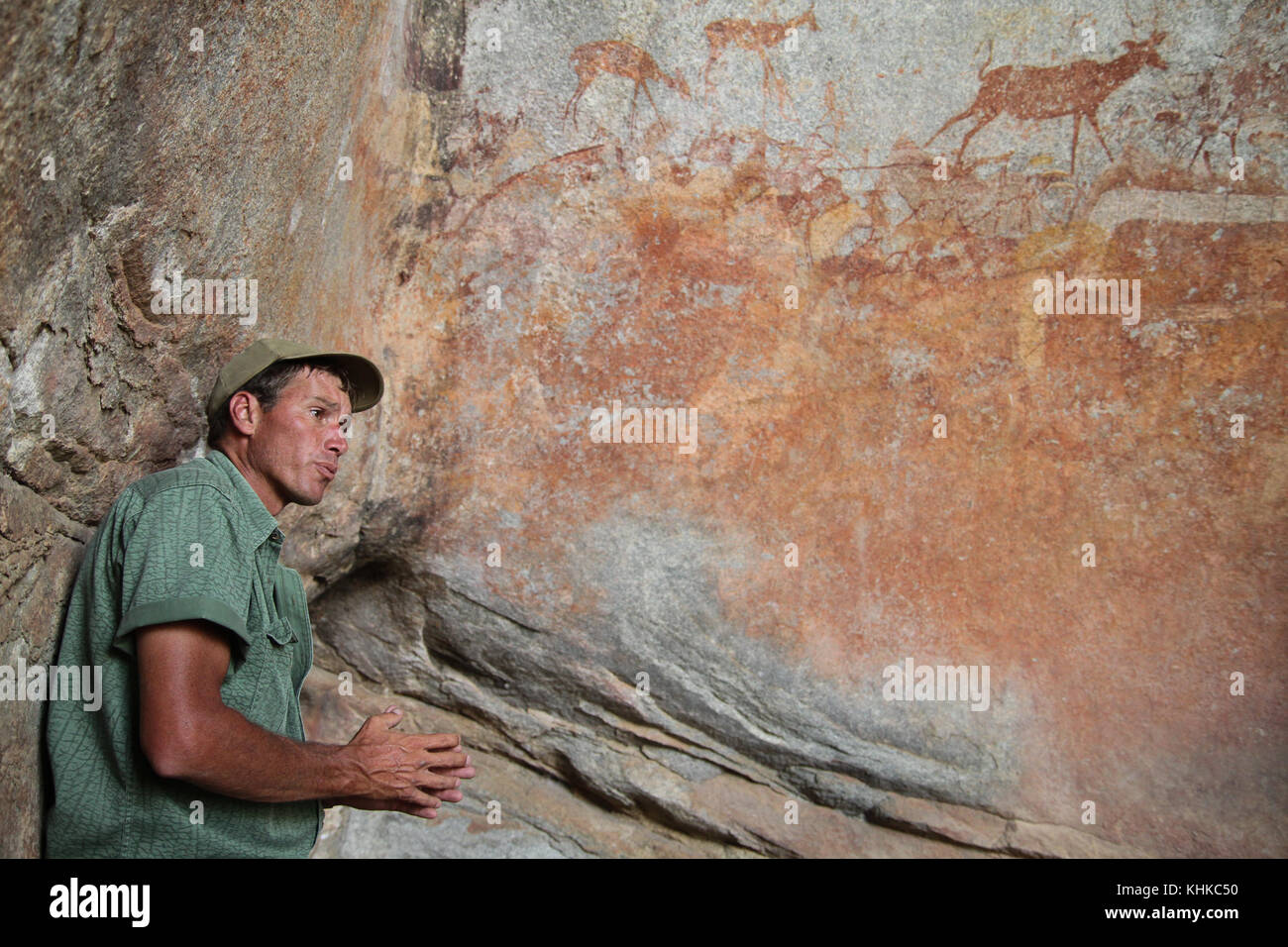 MATOPO, ZIMBABWE -  17 October. Game ranger Ian Harmer talks to tourists about bushmen rock painting in the Nswatugi Cave in the Matobo National Park. Credit: David Mbiyu/Alamy Live News Stock Photo
