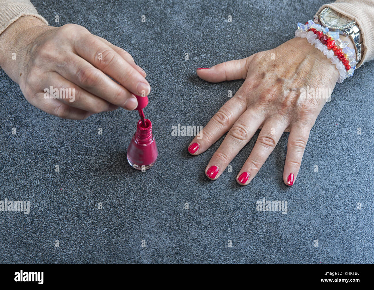 Manicure. Old Woman Hands Polishing Nails With Red Nail Polish In Beauty  Salon Stock Photo - Alamy