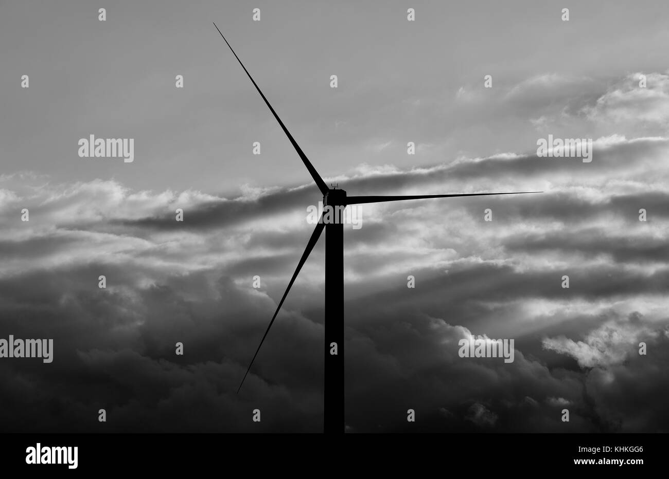 Silhouette of wind turbine at dawn with low clouds, black and white ...