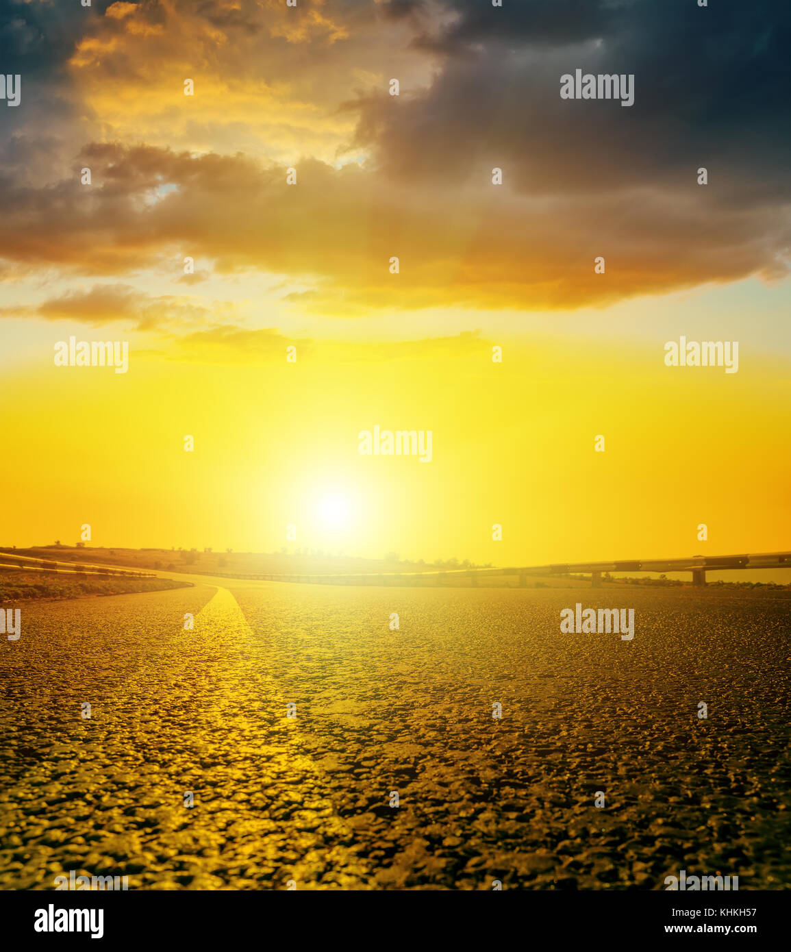 yellow sunset with dark clouds over asphalt road Stock Photo - Alamy