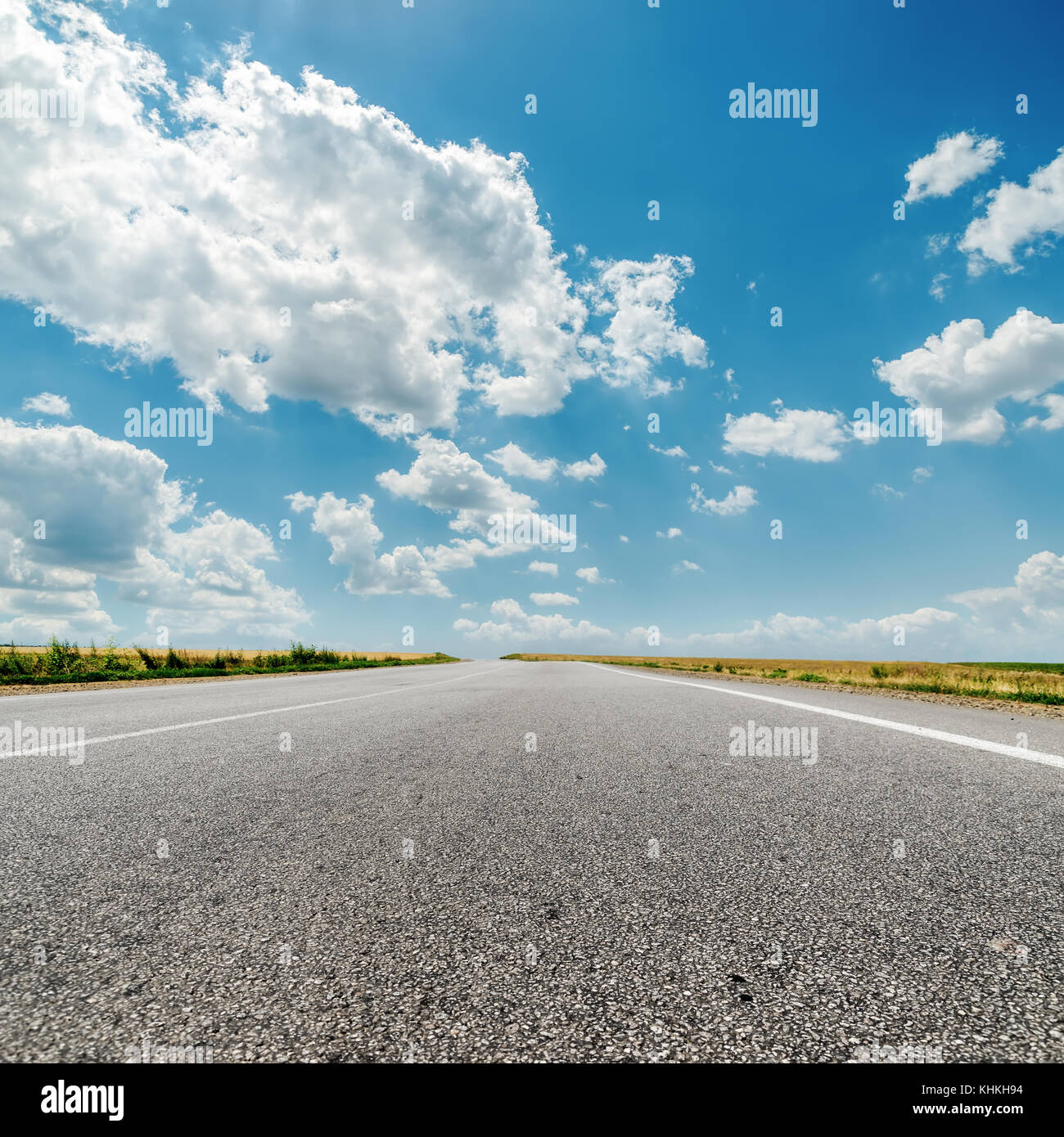 asphalt road to horizon and clouds over it Stock Photo - Alamy