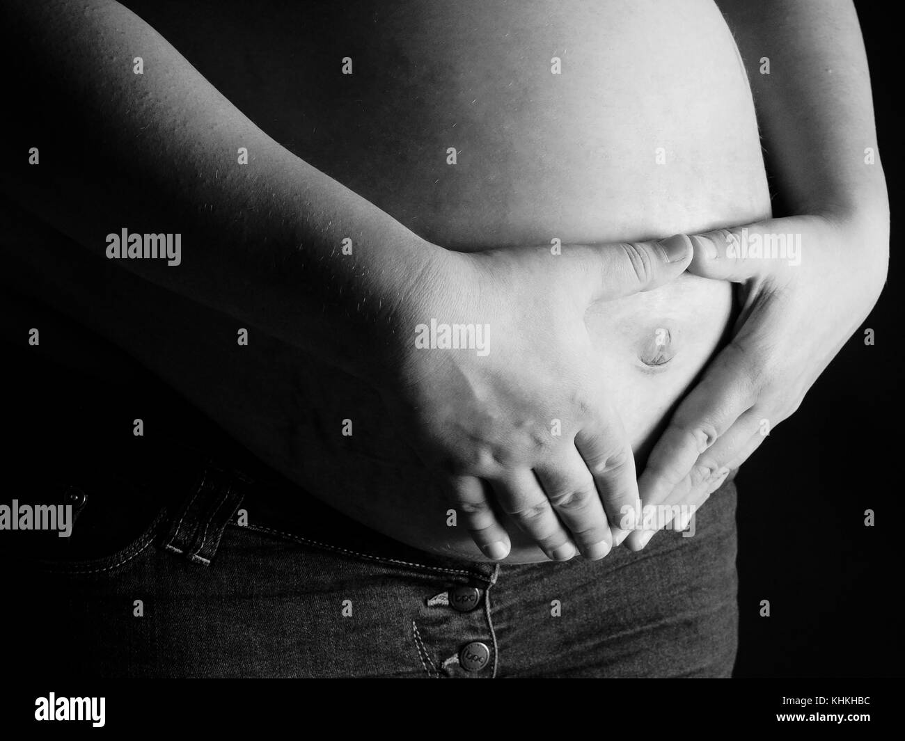 The woman holding a pregnant woman's belly Stock Photo