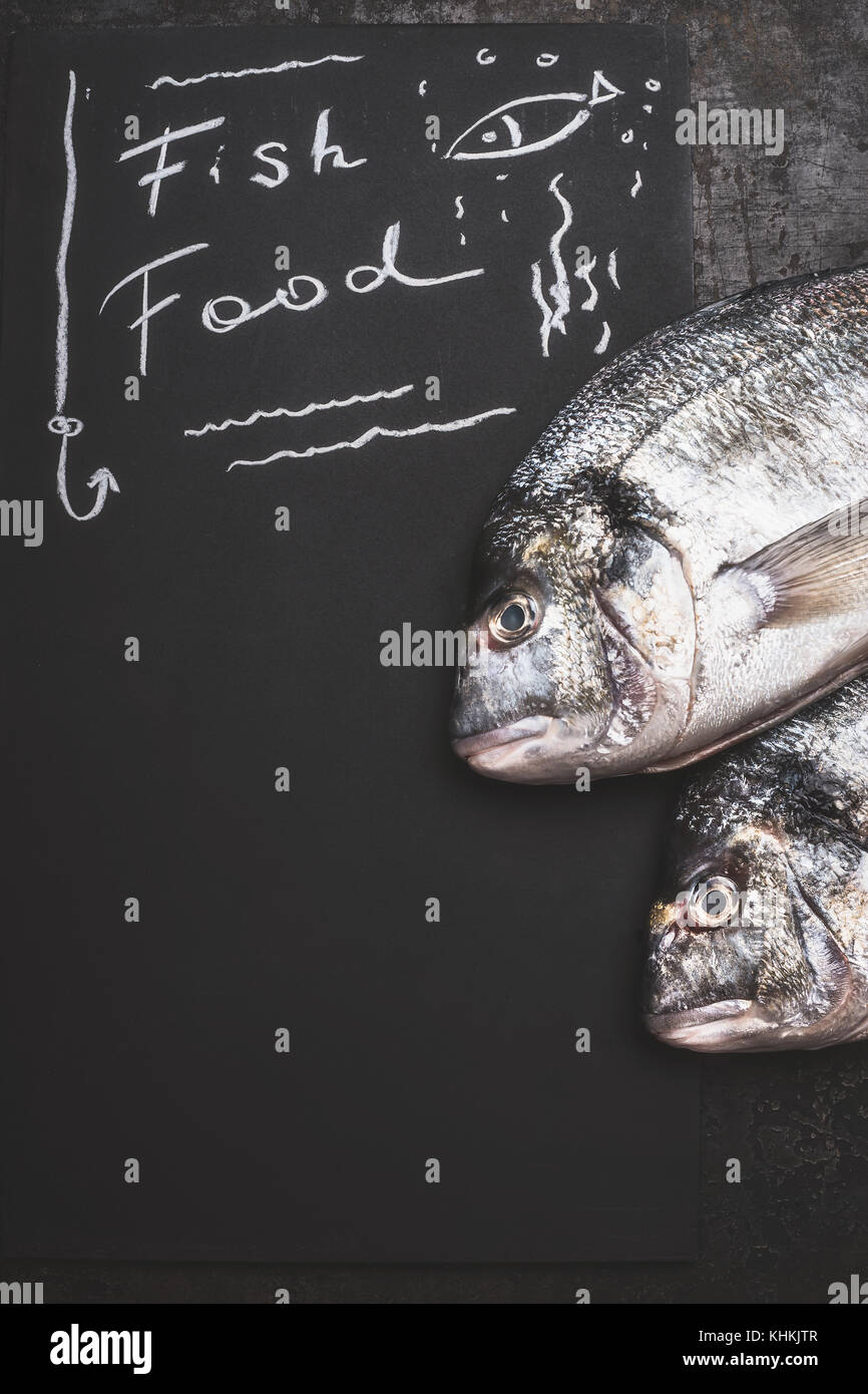 Fish food , handwriting text on black chalkboard background with raw ...