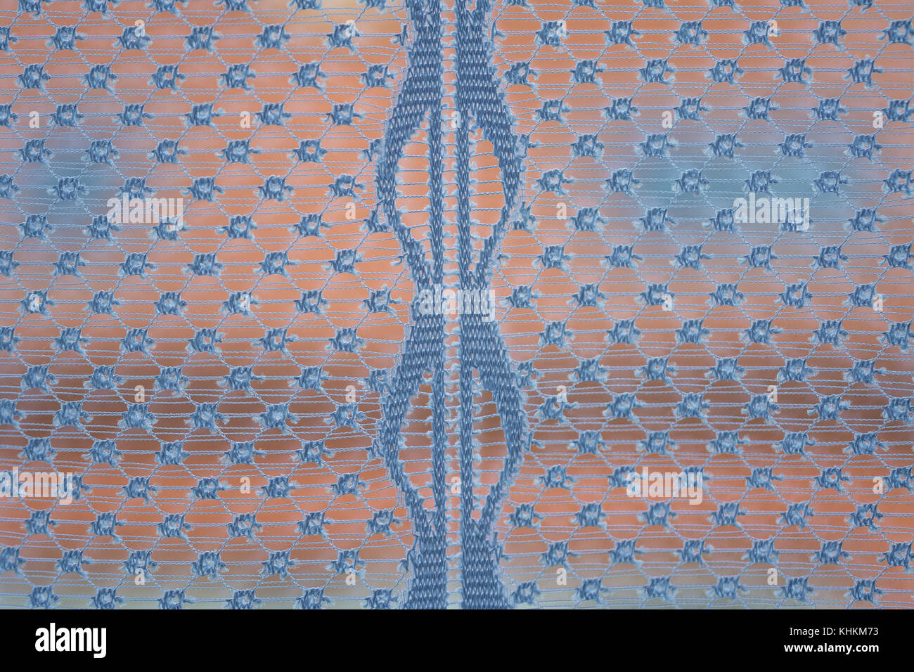 Morning view from window with curtain. Close-up of sheer textile with roof of a house in the background. Stock Photo