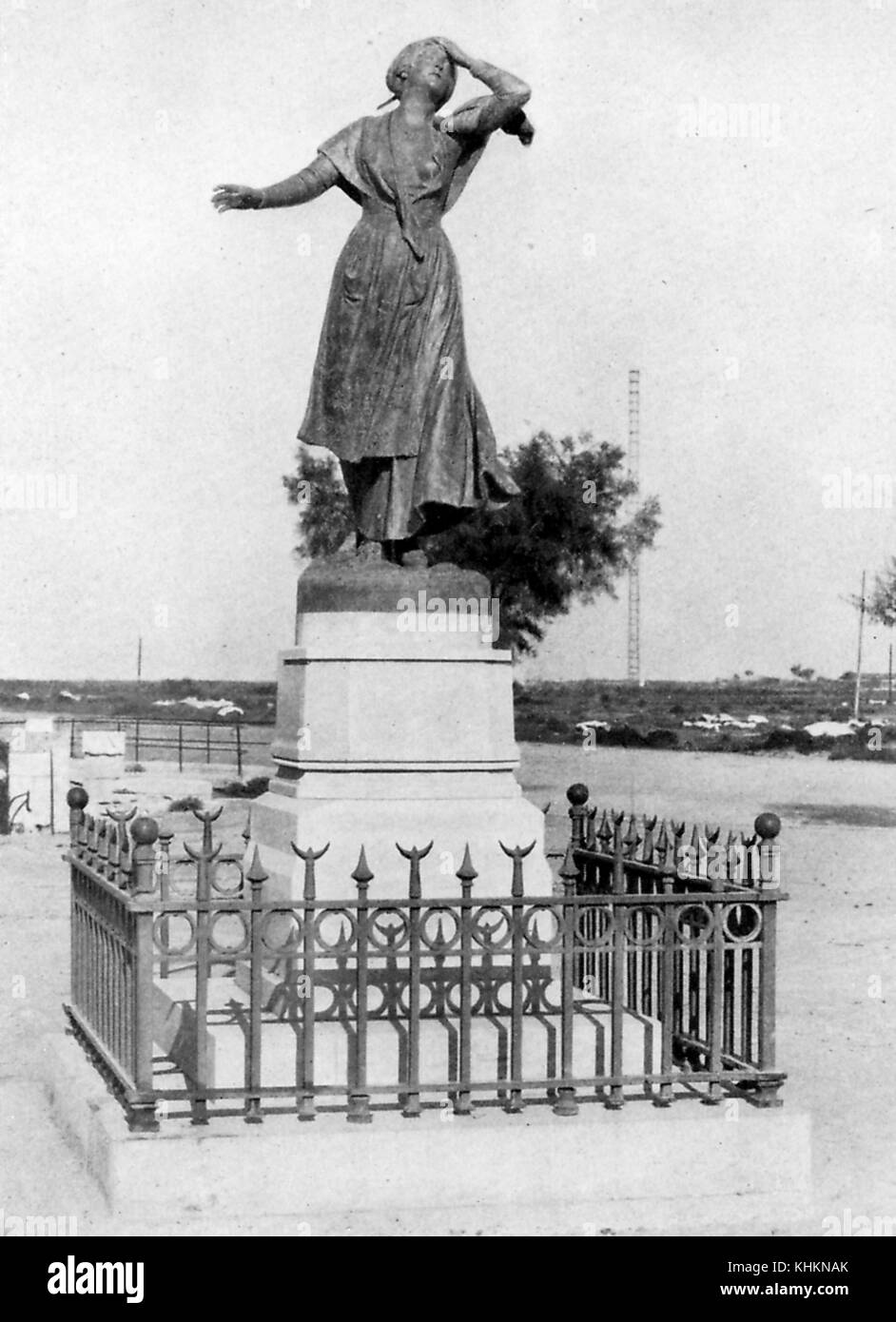 A photograph of a statue of a woman who is wearing a dress, her body posture indicates that she experiencing agony, she is the the central character of a fictional French poem, she escaped her father's home to be with her chosen lover of whom her father disapproves, the statue stands in the city to which she escaped, Saintes-Maries-de-la-Mer, Camargue, France, July, 1922. Stock Photo